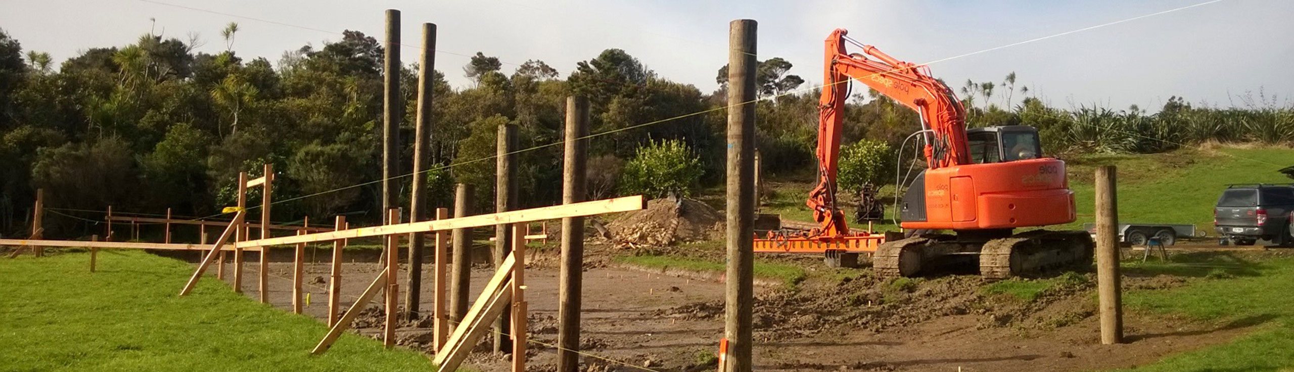 Hydraulic excavator prepares building platform after completion of geotech report.